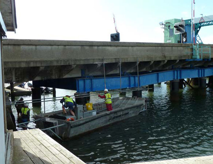 Scaffolders working on marine access below a bridge structure